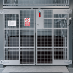 Secure industrial lift cage with mesh double doors, CCTV camera, and access control system at a self-storage facility.